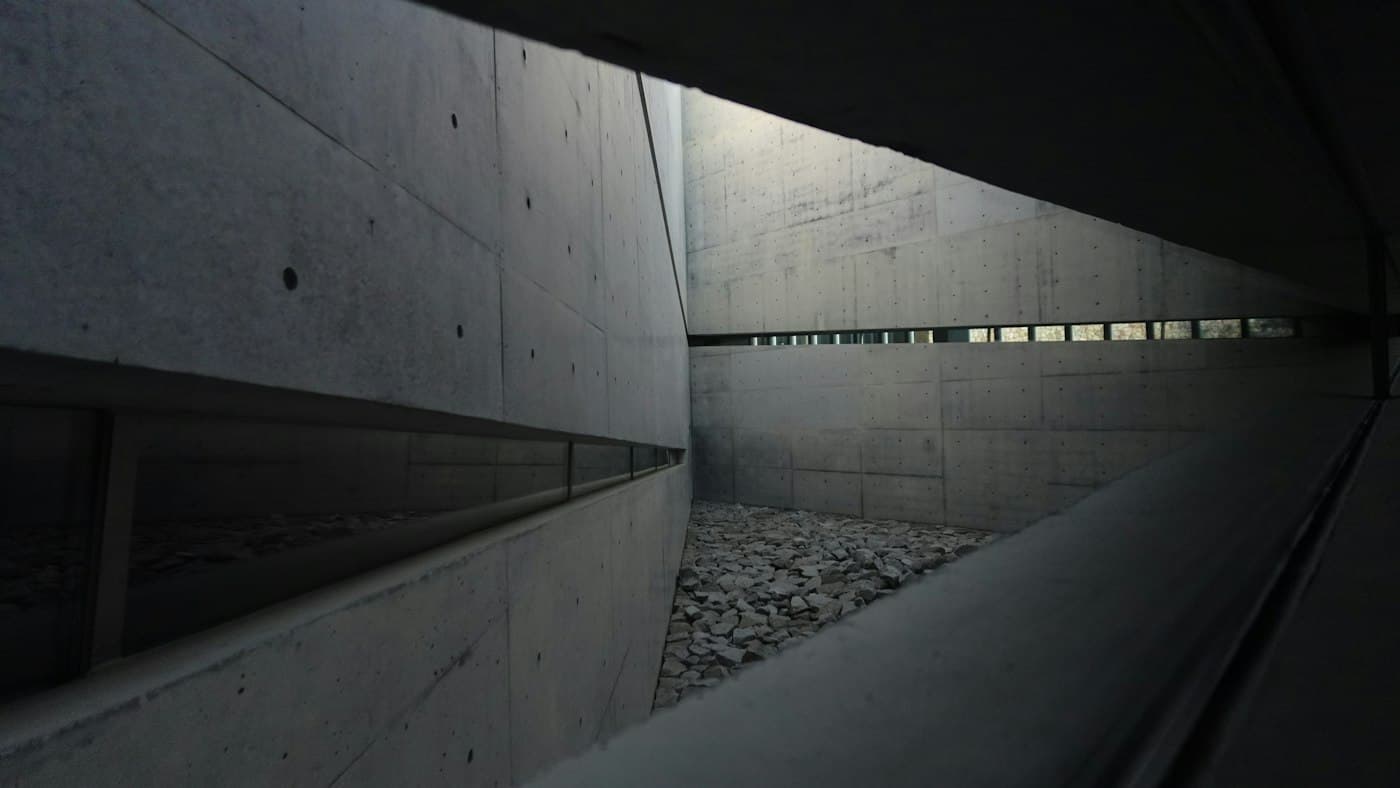 Pátio de arquitetura em concreto, com formas geométricas e luz natural