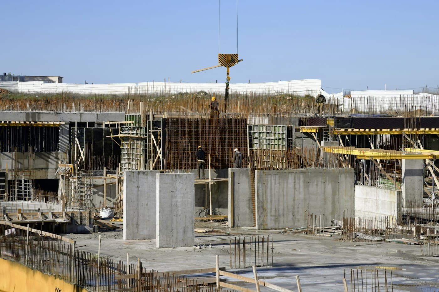 Estrutura de concreto em construção com formas, armaduras e equipamento de elevação