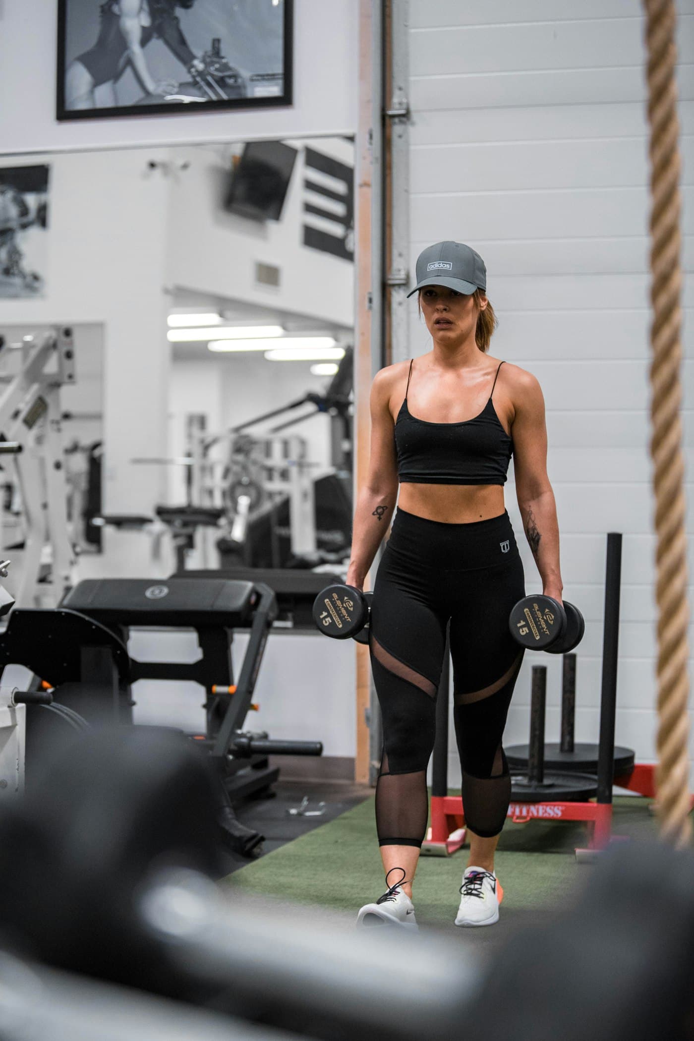 Atleta caminhando com halteres em uma academia